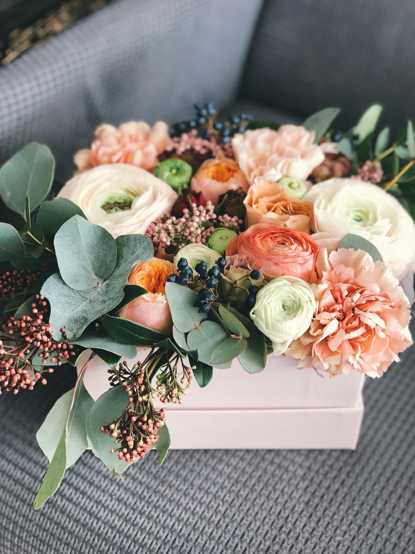 Bridal shower centerpiece of blush garden roses, white ranunculus, eucalyptus, and lisianthus in a footed compote, designed by a Sedalia, MO florist for a Pettis County wedding shower