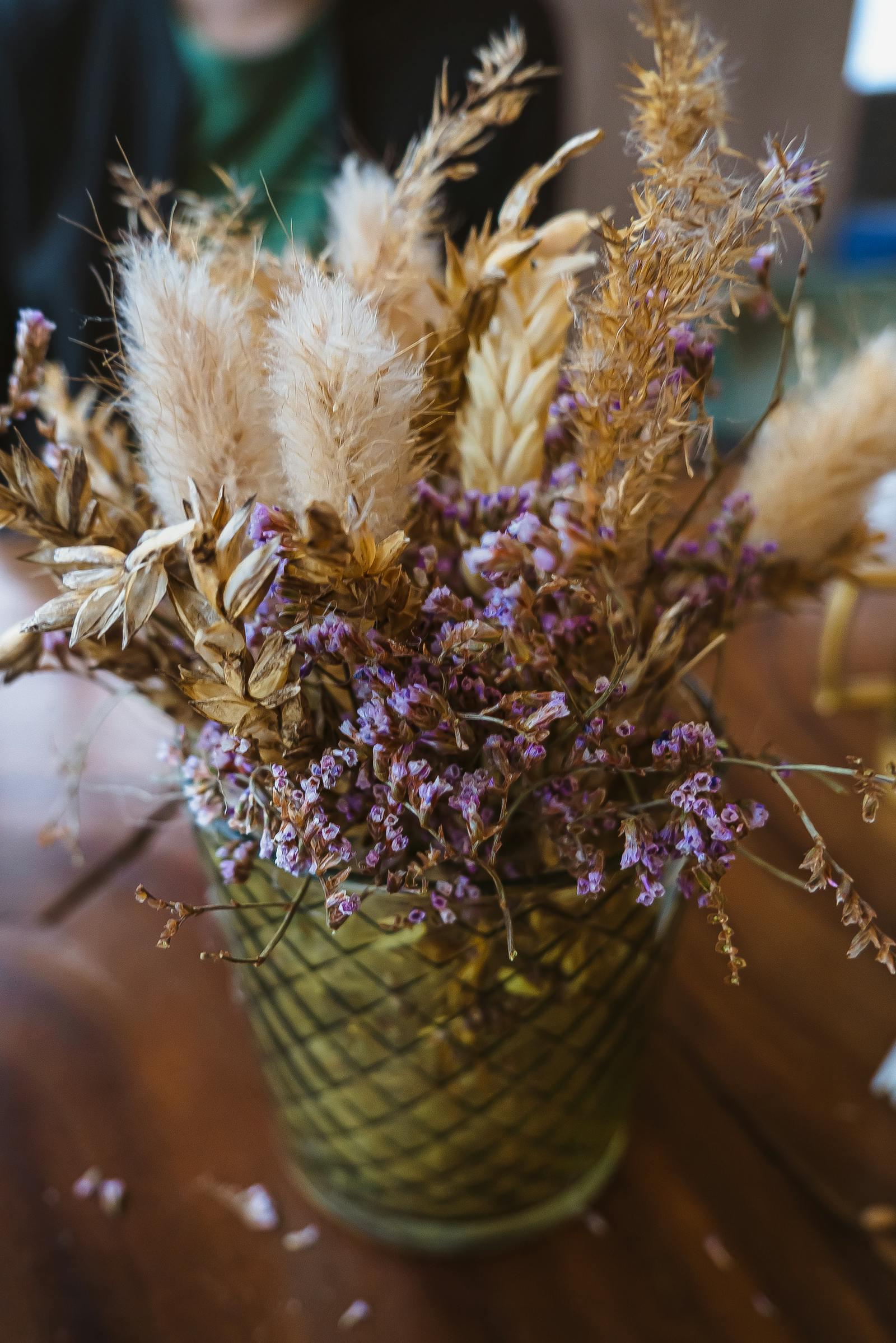 Sustainable dried flower arrangement with lavender, eucalyptus, pampas grass, and statice in a stoneware vase on a Sedalia, MO farmhouse table