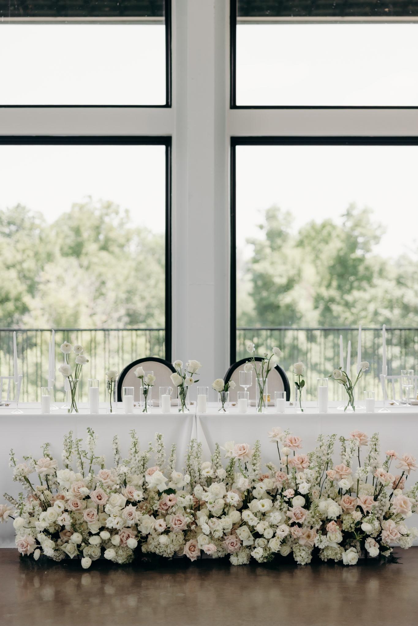 Sweetheart table with a lush floor garden of white and blush florals