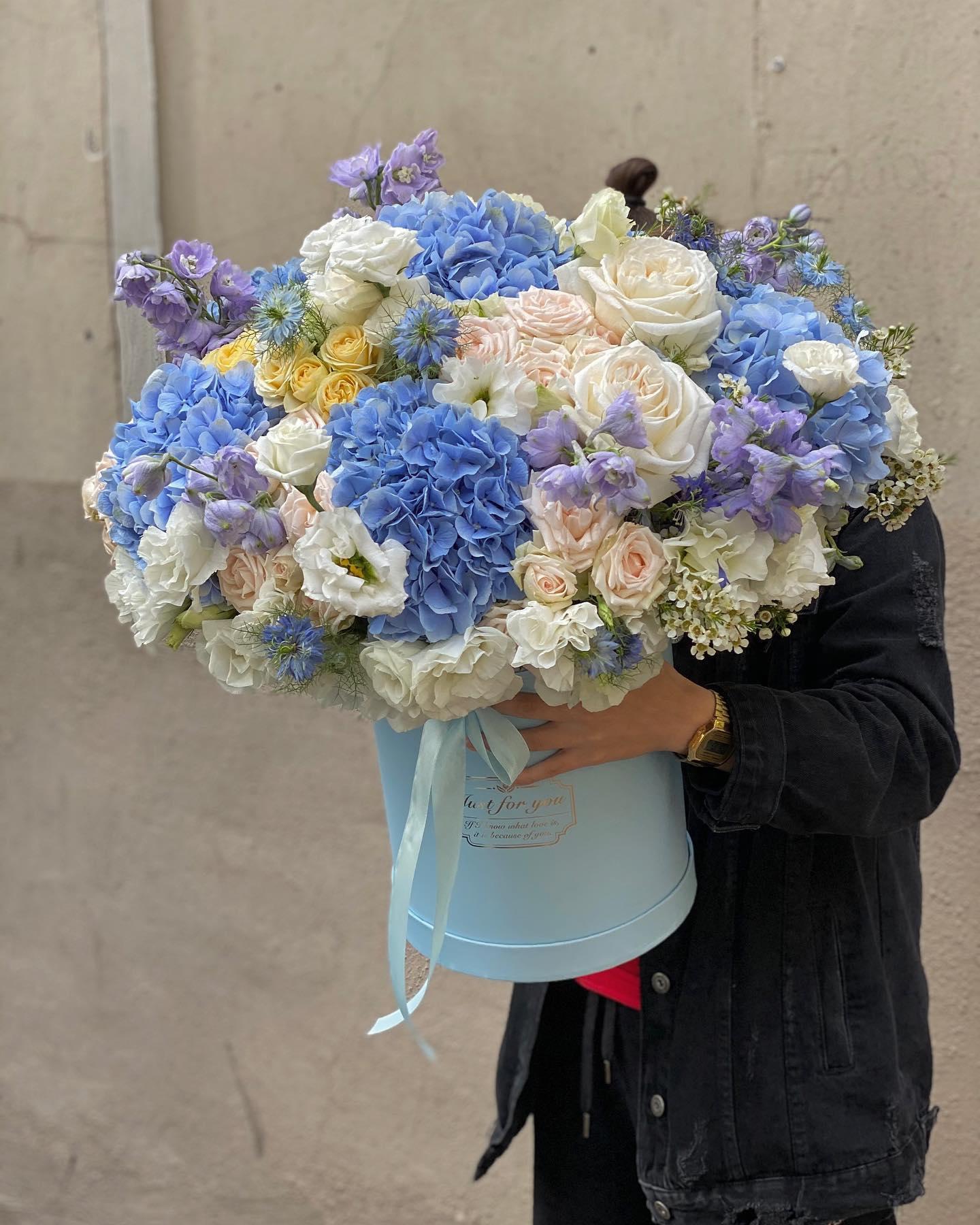 Elegant white and peach sympathy spray with roses, hydrangea, and greenery for funeral service