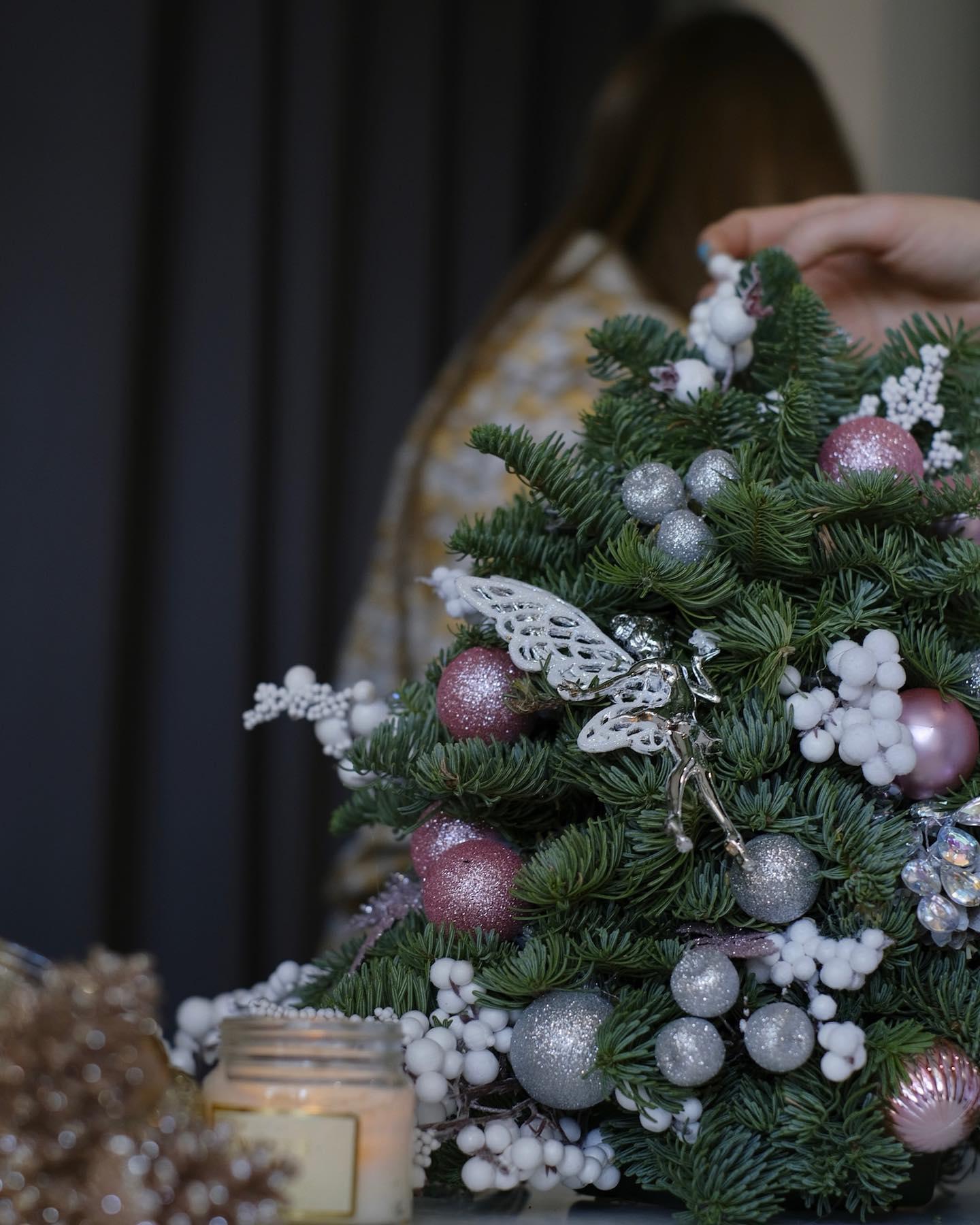 Holiday advent wreath with red and gold ornaments, evergreen branches, and lit candle — Sedalia florist