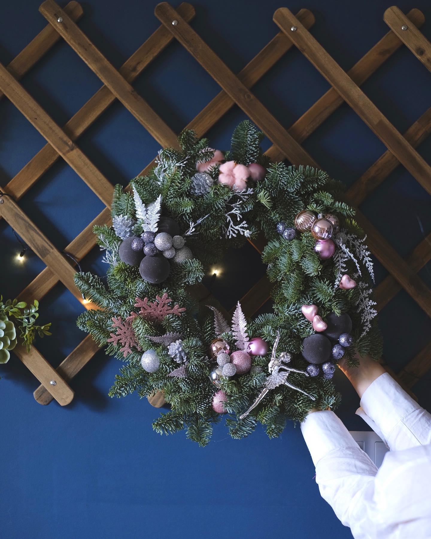 Comforting sympathy basket with soft pastel flowers, white roses, and trailing greenery