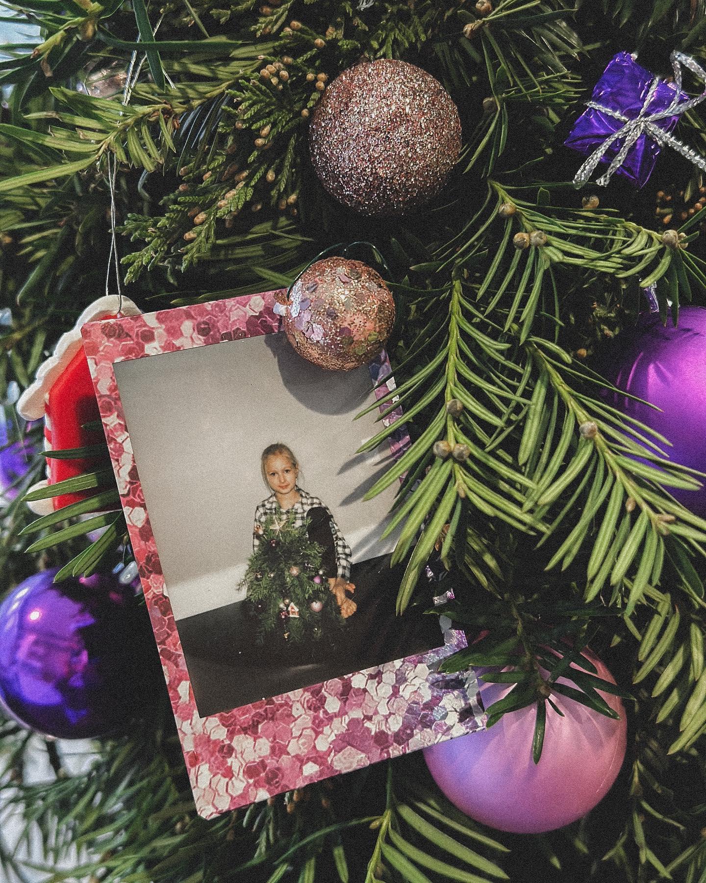 Kids holiday wreath workshop with tables full of evergreens, ornaments, and craft supplies