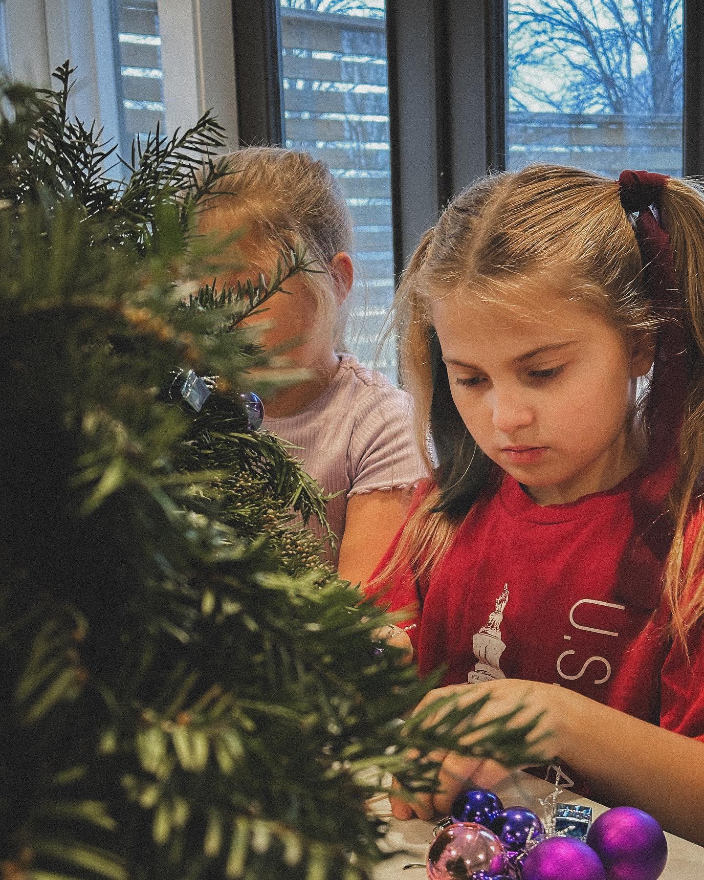 Kids arranging evergreen branches and holiday accents at community floral design class