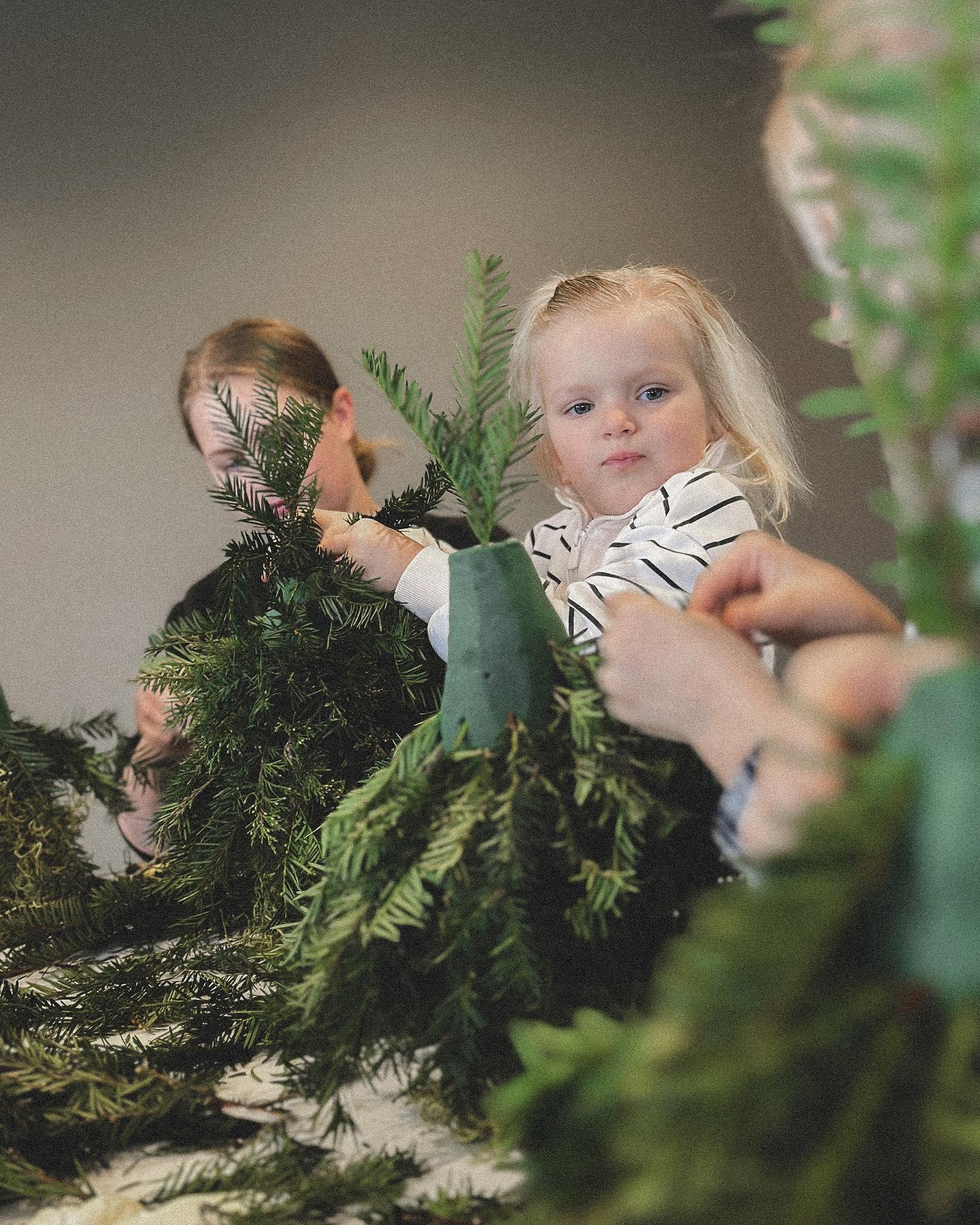 Children proudly working on holiday evergreen centerpieces at Sedalia community event