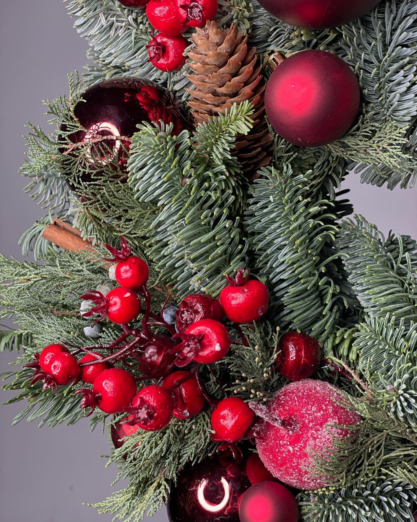 Evergreen holiday mantel garland with angel figurine, gold bows, and frosted red apples